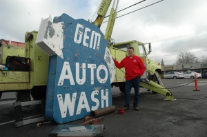 Owner Reed Hollingshead poses with The iconic neon Gem Auto Wash sign. 